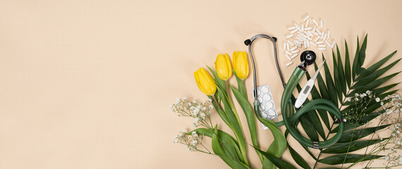 Bouquet of flowers and stethoscope on a beige background, a place for text, happy doctors day, nurses week and other medical holidays.