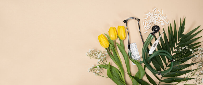 Bouquet Of Flowers And Stethoscope On A Beige Background, A Place For Text, Happy Doctors Day, Nurses Week And Other Medical Holidays.