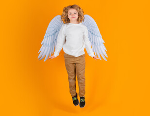 Little angel jump, kids jumping, full body. Cute angel kid, studio portrait. Blonde curly little...