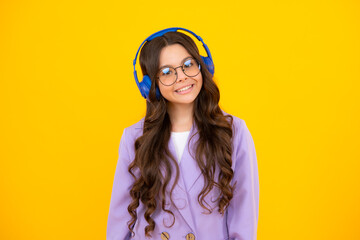 Child music concept. Teenager child girl dances in rhythm of melody, listens song in headphones. Child listening to music through earphones.