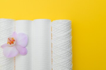 Water filters. Carbon cartridges and a glass on a yellow background. Household filtration system