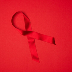 Cancer ribbon on red background. Health care. AIDS prevention concept. Hiv and cancer awareness.