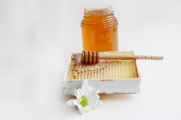 Jars of honey. Honey in honeycombs with a wooden spoon for honey.