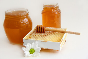 Jars of honey. Honey in honeycombs with a wooden spoon for honey.