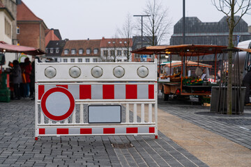 Plastic red and white barrier with a stop signal fume resurrecting entry to the peasant market.