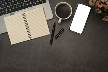 Top view, Flat lay smart phone, laptop, notepad and cup of coffee on stone table. Copy space for your text