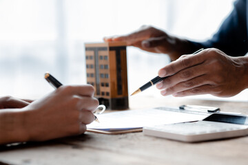 House sales representatives, sales representatives recommend housing details in the project to customers who are interested in viewing the houses in the project. Real estate trading concept.