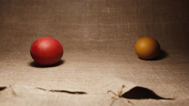 Easter celebrations. Easter Eggs. Brown and red chicken eggs. Painted Easter Eggs on a brown linen bedspread. An Easter egg rolling on a linen bedspread.