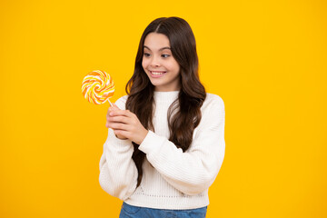 Excited face. Teenage girl with candy lollipop, happy child 12, 13, 14 years old eating big sugar lollipop, sweets candy. Happy face, positive and smiling emotions of teenager girl.