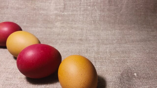 Brown, red and yellow chicken eggs. Painted easter eggs on a brown linen bedspread. Easter eggs. 
