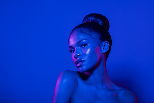 Fashion Portrait Model In Colorful Bright Lights With Trendy Makeup Posing In Studio.Closeup African American Woman In Blue And Pink Lighting Filters With Copy Space.