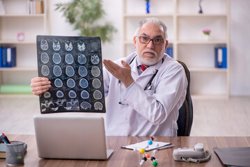 Old male doctor radiologist working in the clinic
