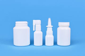 Medication for cold and flue. Nasal spray, throat spray, pills on blue background