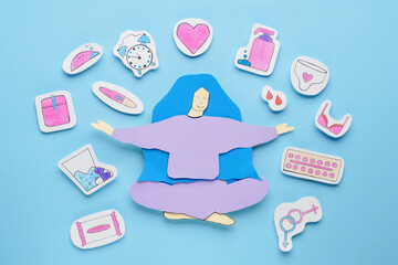 Woman`s health. Paper female figure and different stickers on light blue background, flat lay