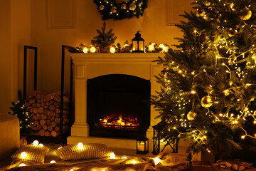 Beautiful living room interior with burning fireplace and Christmas tree in evening