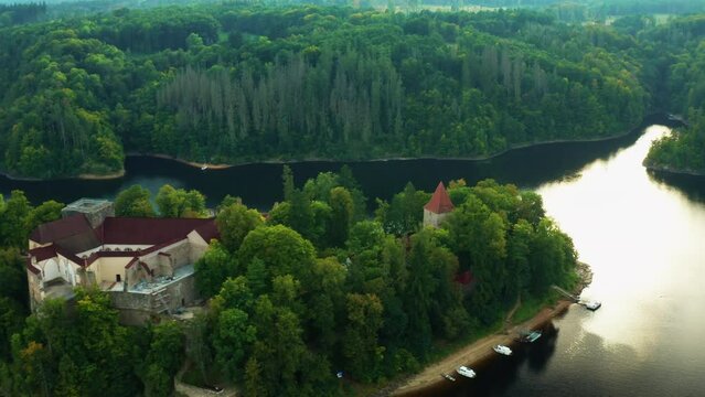 Moving along Zvikov castle with traditional red roofs, river and forest at sunset in South Bohemia region in Czech Republic