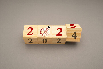 Flipping 2024 to 2025 on wooden cubes on a gray background