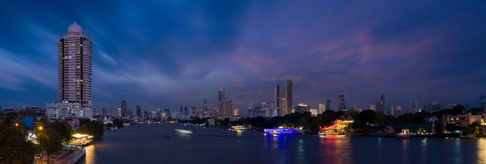 Panoramic Bangkok cityscape. Night view of tall buildings and Chao Phraya river in business district. Nightfall. Bangkok,Thailand