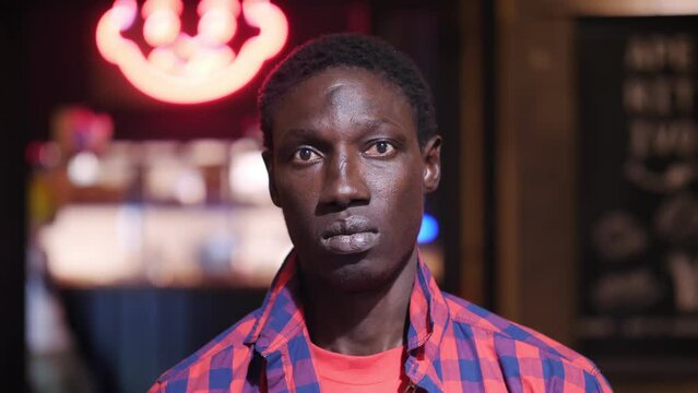 pensive african man in subway underpass stares at camera