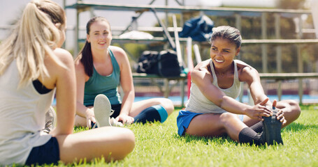 Stretching, fitness and sports women with teamwork, support and exercise, wellness and health on grass or field. Training, workout and athlete group of people in diversity, talking and relax on floor