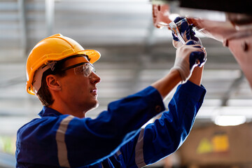 A team of male and female engineers meeting to inspect computer-controlled steel welding robots. Plan for rehearsals and installation for use.