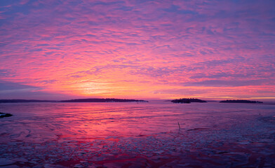 Panorama view of winter landscape and colorful sunrise over the lake on a cold morning. Photo taken in Sweden.