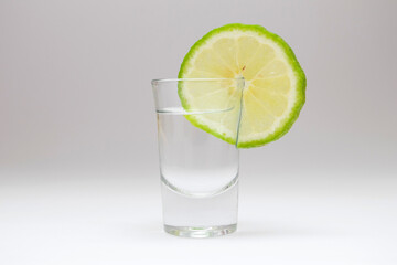 Tequila shot with lime on white