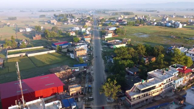 An aerial view of a straight road bordered by houses in the town of Nepalgunj.