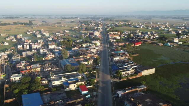 An aerial view of a straight road bordered by houses in the town of Nepalgunj.