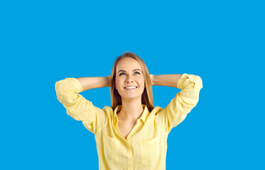 Happy young Caucasian woman isolated on blue studio background look up at blank empty copy space thinking. Smiling girl dream or imagine, make plans. Sale deal or offer. Advertising.