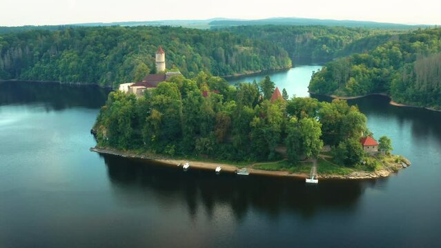 Fly over the tree and opening of panoramic view of Zvikov Castle on the hill surrounded by river. 