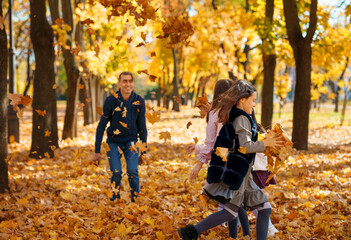 portrait of a big family in autumn city park, happy parents and children playing together and throwing yellow leaves, beautiful nature, bright sunny day