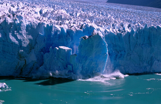 A serac calves off a glacier into a lake in Parque Nacional de los Claciares, Patagonia, Argentina.