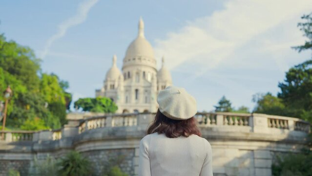Attractive woman walking towards Sacre Coeur Basilica on Montmartre in Paris, slow motion