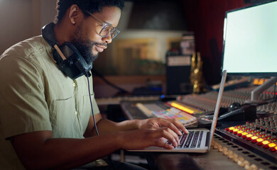Black man, thinking and laptop for music recording, sound engineering or song composition in...