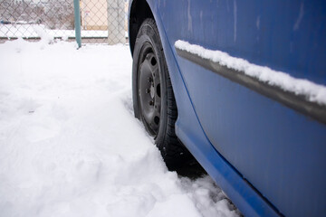 Blue car standing in the snow closeup