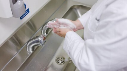 Close up of chef washing hands in commercial kitchen environment