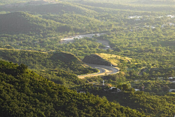 Top view landscape of a curved highway road with mountains in golden hour from puerto rico