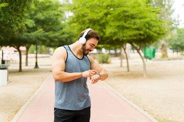 Smiling man checking his smartwatch while exercising