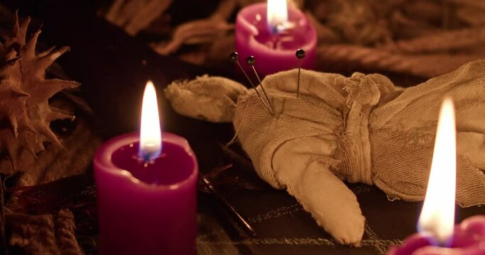 Occultist dripping hot wax on voodoo doll, magic rituals, black spell, horror.