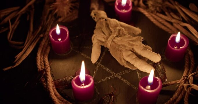 Occultist dripping hot wax on voodoo doll, magic rituals, black spell, horror.