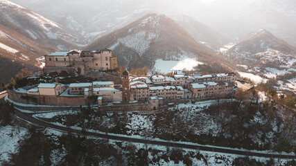 Italy, January 2023: aerial view of the medieval village of Frontone covered in snow. The village...