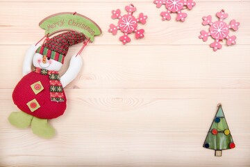 Happy New Year. Merry Christmas. New Year's card and copy space. Snowman, Christmas tree and snowflakes as decoration. Background - textured wooden surface made of light wood.