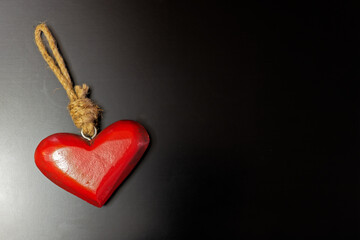 Wooden heart on dark background - symbolic for love and valentines day - copy space