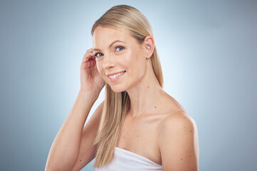 Hair care, beauty and portrait of a clean woman isolated on a blue background in a studio. Spa, wellness and cosmetology model with facial makeup, skin cosmetics and dermatology on a backdrop