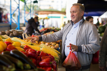 Man choosing vegetables in greengrocery