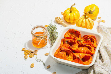 Oven baked pumpkin slices with honey, rosemary and seeds. Vegan food, trendy hard light, dark shadow