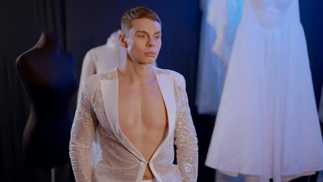 fashion model man in atelier of wedding store, gay person in trendy shiny jacket, actor of drag show