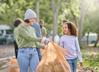 Volunteer, child and woman cleaning plastic in park with garbage bag for a clean environment....