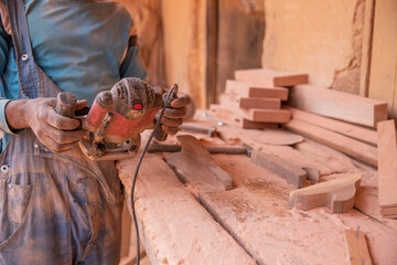 Close-up of a sander being held by an african carpenter at work.